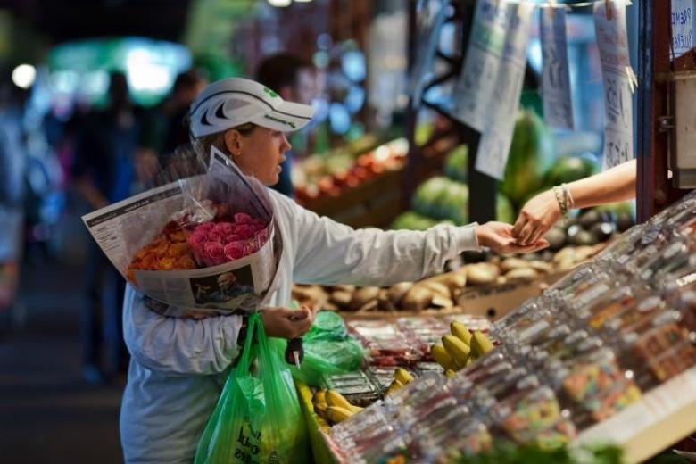 一位妇女在苏拉德农贸市场买鲜花.